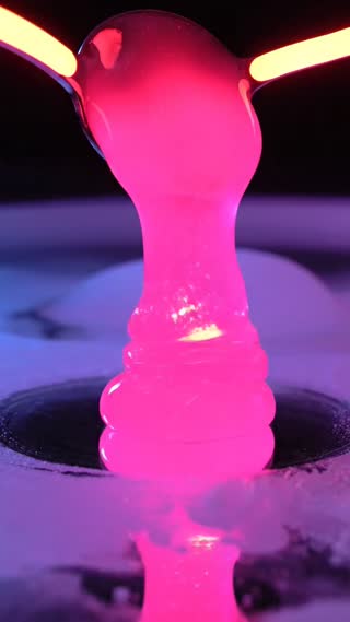 A glowing spoon pours neon pink
molten candy over a frosted ice mirror slab. The
candy forms thick ribbons across the cold surface.
As the candy hits the ice, it
thickens and sparkles, spreading with a wet gloss and
slow drip. Sound: hot syrup pour, cold sizzle, sticky
crackle. Visuals: vibrant lighting and close-up of
texture contrast.