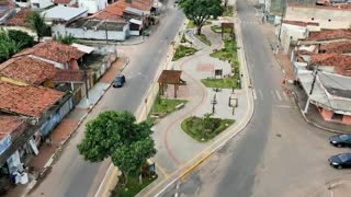 Generate a 10-second ultra realistic cinematic aerial video based on the finalized urban revitalization image. Preserve the exact urban structure, avenue dimensions, architecture, landscaping, geometry and spatial composition of the original project. Do not modify buildings, roads, sidewalks, park layout or infrastructure during animation.
Animate all existing vehicles with realistic Brazilian traffic behavior, respecting lanes, directions, spacing, safe distances and natural speeds. Traffic must appear smooth and physically realistic, without collisions, overlaps or impossible movements.
Use only stabilized low-altitude drone movement performing a smooth flyover across the entire extension of the project. The camera must remain above the park area in a continuous aerial tracking shot, avoiding ground-level scenes, close-up shots or detailed focus on people.
People should appear naturally distributed throughout the park only as small background elements viewed from above, maintaining realistic movement and density without becoming the central focus of the scene.
Vegetation should move softly with natural wind simulation. Maintain warm golden hour sunlight, realistic reflections, cinematic shadows and believable lighting.
The atmosphere must communicate modernization, urban wellness, accessibility, quality of life and community integration.
Photorealistic quality, cinematic stabilization, highly believable Brazilian urban environment, architectural visualization aesthetic, ultra detailed, 4K quality. Duration: 10 seconds.
