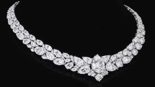 full luxury diamond necklace fully visible (no cropping, no zoom cut), centered composition, entire necklace inside frame with safe margins, on pure deep black background, elegant gentle circular rotation (10–15 degrees), smooth cinematic slow motion, macro product shot, ultra realistic, high contrast lighting, soft top spotlight + subtle rim light, perfectly sharp focus

realistic sparkle across ALL diamonds and crystals, continuous micro light reflections moving across the entire necklace, star-like glints appearing on different stones (not only center), controlled shimmer, light sweep traveling smoothly from left to right across all crystals, no overexposure, no flicker

glossy reflection on black surface, premium luxury jewelry commercial style, ultra detailed, 4K, no distortion, no blur, no cropping, keep full necklace visible at all times