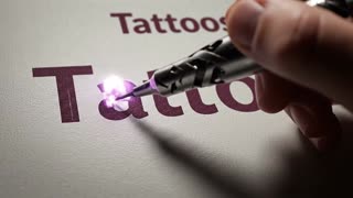 Bitte animiere diese Grafik. 

Gehe mit einer tätowier-Nadel auf einen Schriftzug. Bring gern die Schrift in flammen.

Die Farbe der Flamme sollte ein dunkles lila sein (ähnliche Farbe wie in Grafik) 


- Bitte nur keine Texte ergänzen. 
- keine Texte erstellen 

Einfach die bestehende Grafik futuristisch modern  animieren.  In einer filmischen Szene mit professioneller Beleuchtung, flacher Tiefe des Feldes und visuellen Effekte in Filmqualität