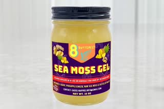 Use the uploaded Sea Moss Gel image as the exact reference. Show ONLY this product jar on a clean premium countertop. A realistic human hand enters the frame and slowly picks up the jar. Camera performs a slow cinematic push-in toward the jar. Keep the product label completely unchanged and readable. Do not redesign the packaging. Do not create a different jar. Do not add another brand. Realistic product commercial photography, natural lighting, shallow depth of field.