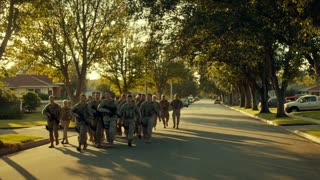 A group of soldiers in modern military uniforms walks down a quiet, tree-lined suburban street during the golden hour, their expressions shifting from focus to relief as they approach welcoming homes. The camera uses a slow dolly shot, following them from a respectful distance, capturing the warm, nostalgic lighting and the emotional weight of the moment in a cinematic documentary style.