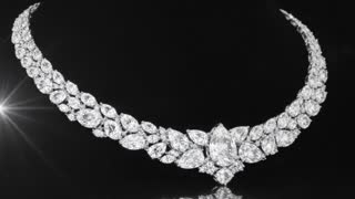 full luxury diamond necklace fully visible (no cropping, no zoom cut), perfectly centered composition, entire necklace inside frame with safe margins, on pure deep black background

elegant slow cinematic circular rotation (10–15 degrees), smooth motion, macro product shot, ultra realistic, high contrast studio lighting, soft top spotlight + subtle rim light, perfectly sharp focus

ULTRA FINE MICRO SPARKLE across ALL diamonds and crystals:
very small size sparkles (micro glints), high density, evenly distributed across every single stone, continuous tiny shimmering points

NO large flashes, NO big star bursts, NO central-only sparkle

each crystal emits subtle micro twinkling reflections, like dust-sized light particles, soft and refined luxury shimmer

continuous flowing light sweep moving gently from left to right across the entire necklace, synchronized with micro sparkle behavior

randomized tiny glints appearing and disappearing across all stones (not repetitive, not patterned)

controlled shimmer, no overexposure, no flicker, no harsh glow

glossy reflection on black surface, premium luxury jewelry commercial style, ultra detailed, 4K, no distortion, no blur, keep full necklace visible at all times