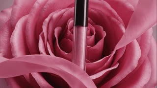 A soft, luxurious beauty animation in macro view. A pink rose slowly moves and breathes, its petals gently unfolding and flowing in slow motion. The lip gloss tube subtly sways and floats together with the rose, as if suspended in air. The movement is smooth, delicate and synchronized — no sharp motion. Light softly glides across the glossy surface, creating refined highlights. Cinematic lighting, shallow depth of field, romantic and premium beauty aesthetic.

Negative prompt:
no fast motion, no shaking, no rotation, no distortion, no melting, no aggressive effects in a minimalist scene with simple composition, clean lines, and focus on essential elements